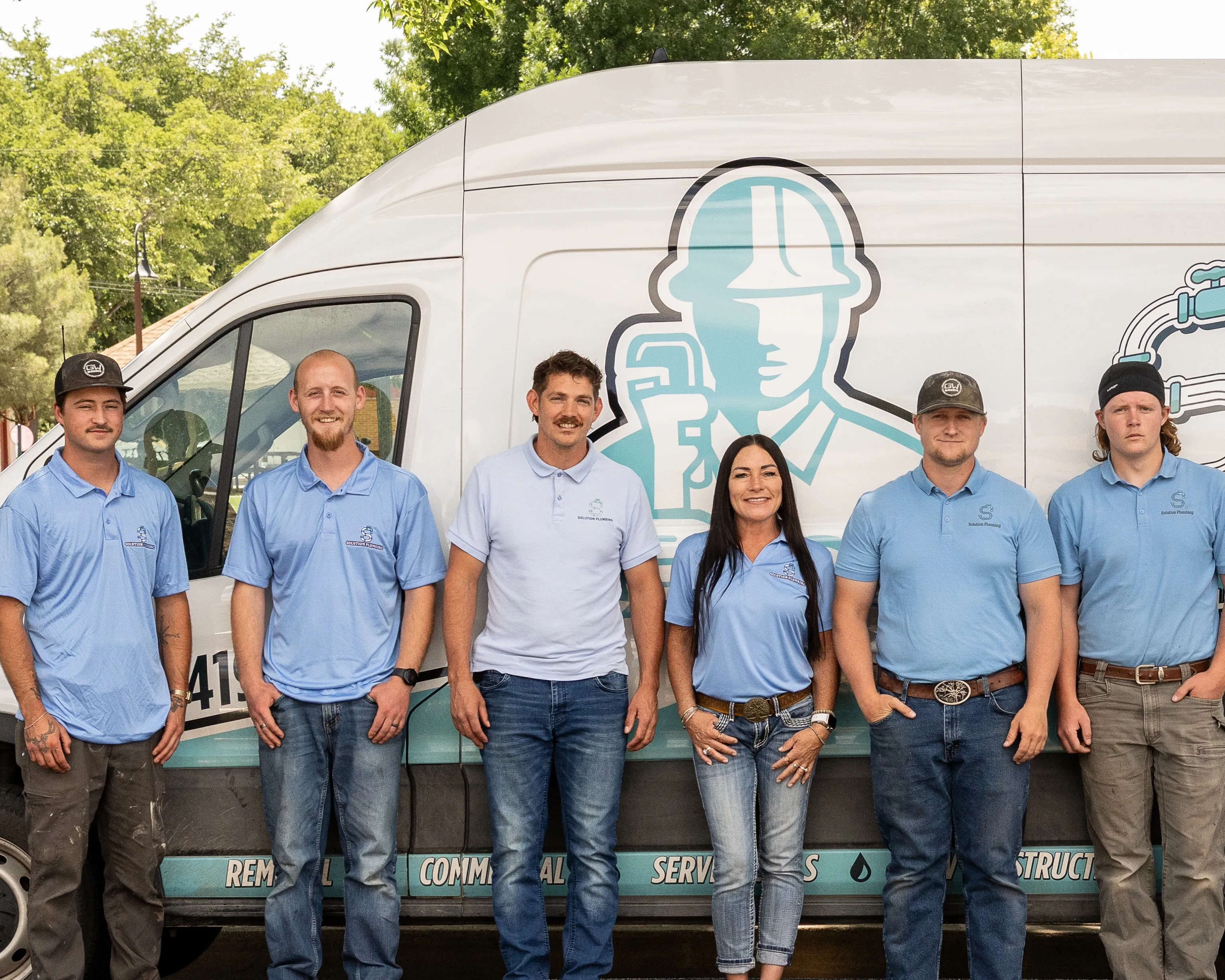 The Solution Plumbing crew gathered at the back of a company van